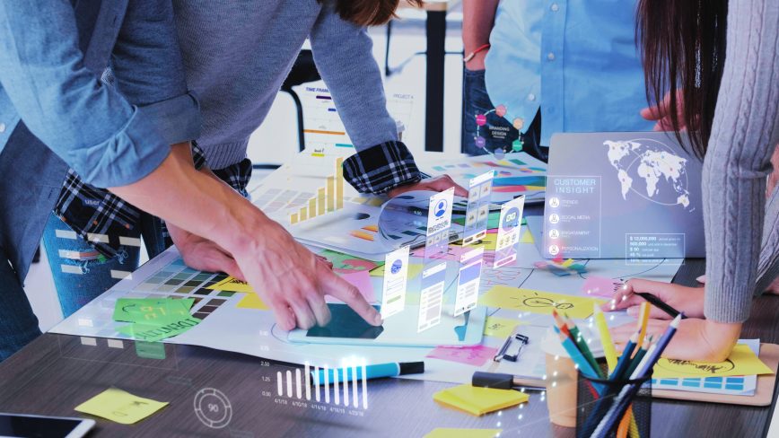 Close up ux developer and ui designer use augmented reality app brainstorming about mobile interface wireframe design on desk at modern office.Creative digital development agency